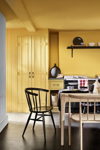 yellow kitchen with pale wood dining table