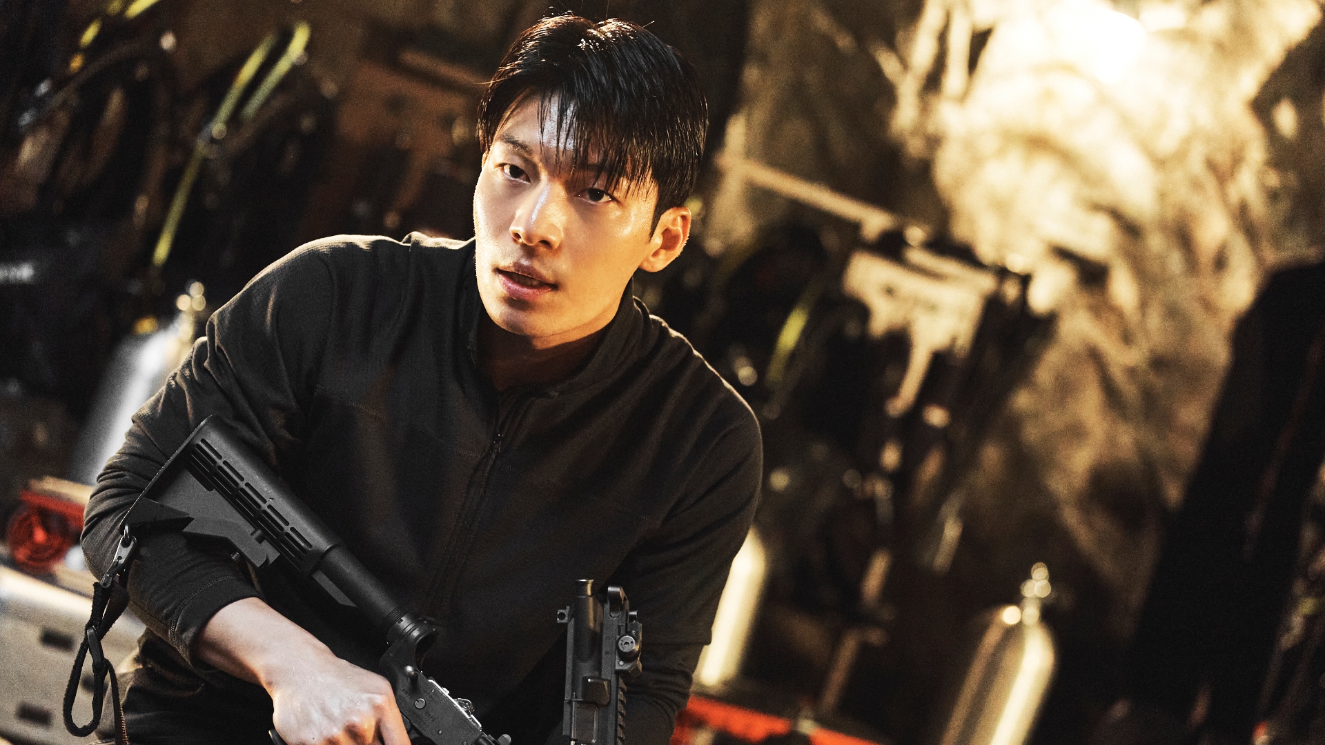 Jun-ho crouches in a cave with a gun in Squid Game season 3