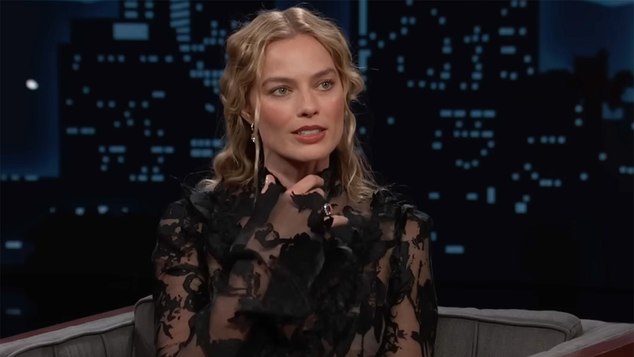 Margot Robbie talking about it getting hot growing up in a black lace dress while sitting in a chair talking to Jimmy Kimmel. 