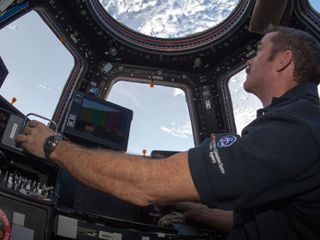 Canadian astronaut Chris Hadfield enjoying the view of the Earth through the cupola on the International Space Station.