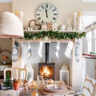 View of a woodburner in a dining room with christmas stockings hung on mantelpiece