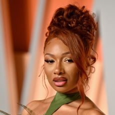 Megan Thee Stallion with red hair and an updo hairstyle.