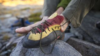 A man tying the laces on his rock climbing shoes