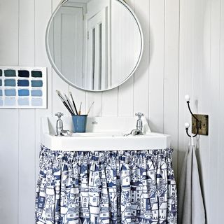 bathroom with white walls and round mirror