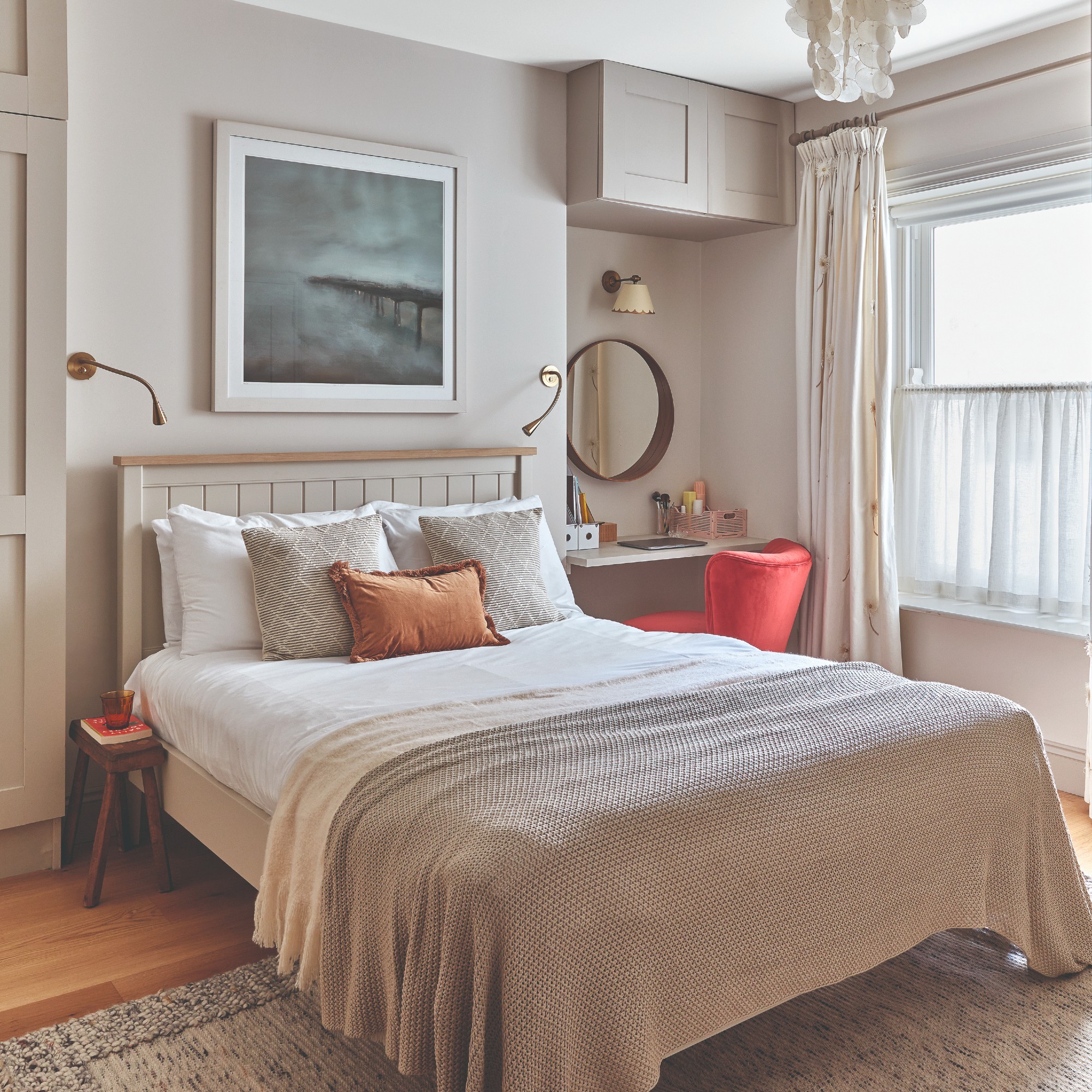 A neutral bedroom with alcoves used for a built-in working-from-home desk/dressing table and a wardrobe on the other side