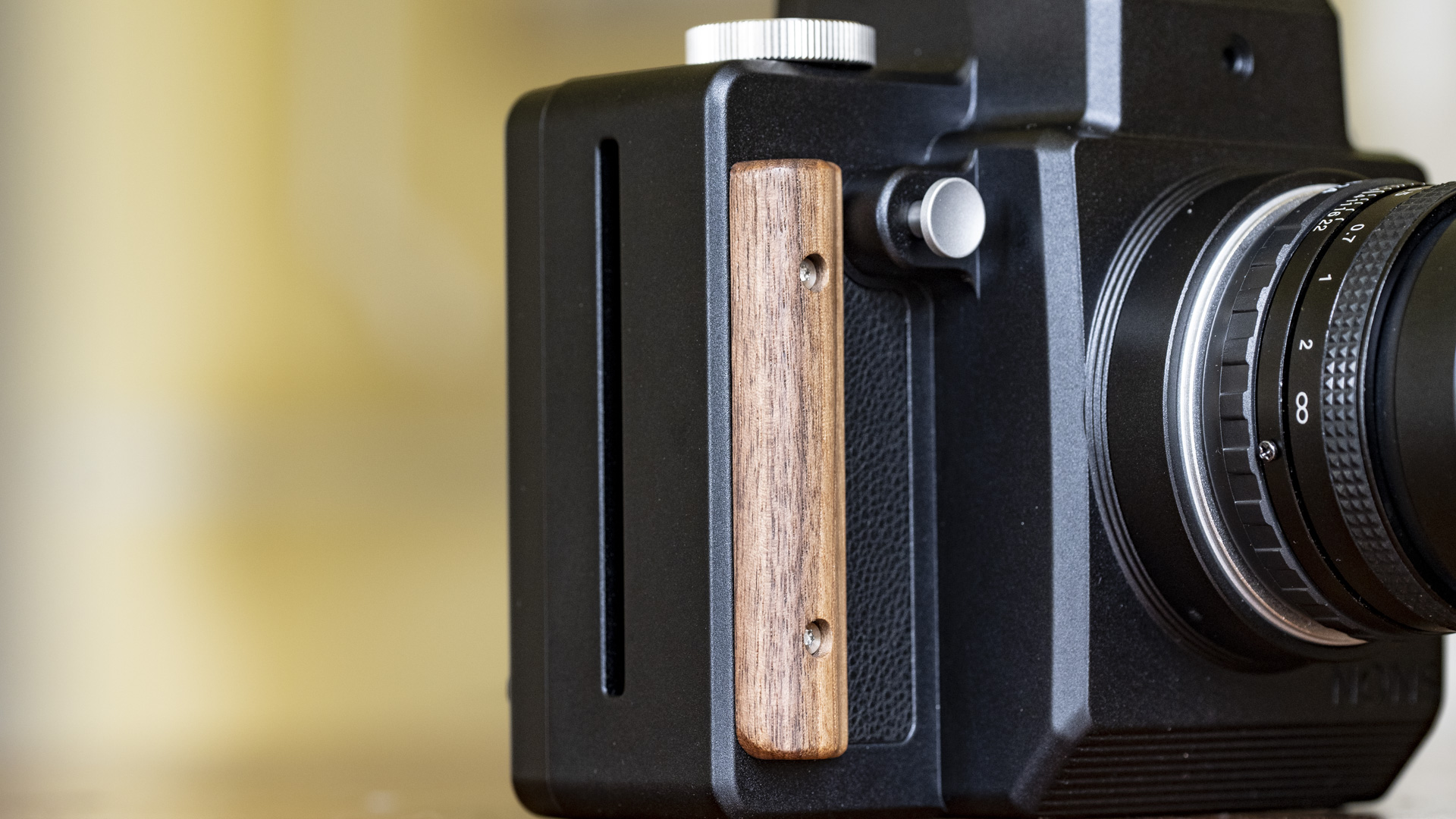 Close up of the Nons SL660 instant camera's wooden grip
