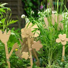  brown cardboard flowers in garden with grass