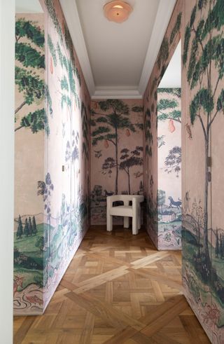 a hallway wallpapered in a mural with hidden doors inset