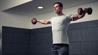Man demonstrates midway position of the lateral raise exercise