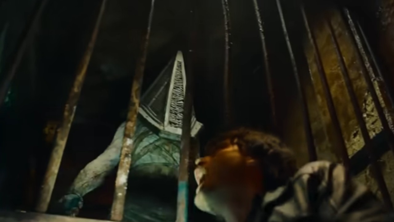 Pyramid Head standing behind a gate in Return to Silent Hill