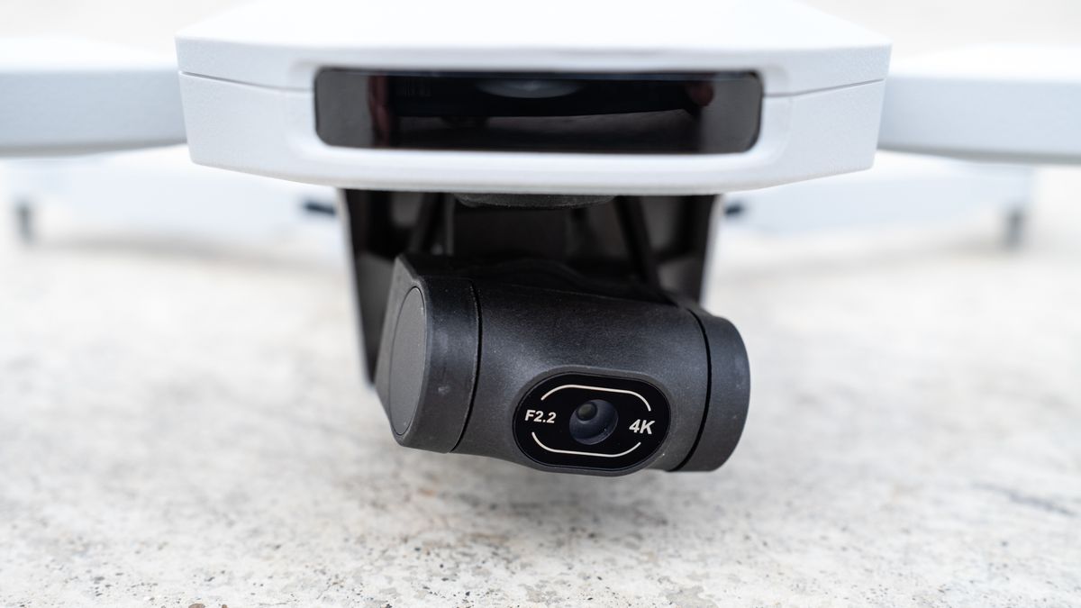 the close-up of the black-cased camera of a white drone.
