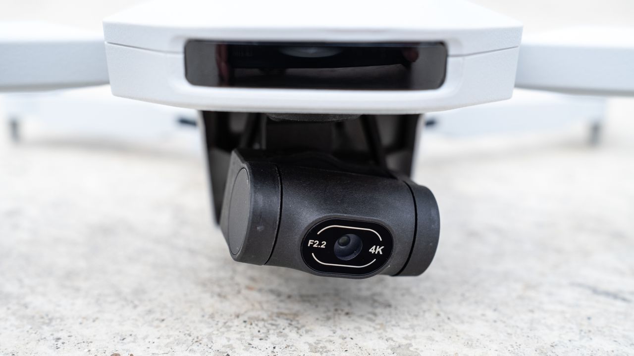 the close-up of the black-cased camera of a white drone.