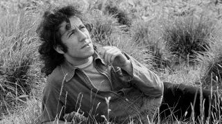 Peter Green of Fleetwood Mac posing for a photograph in a field in 1969