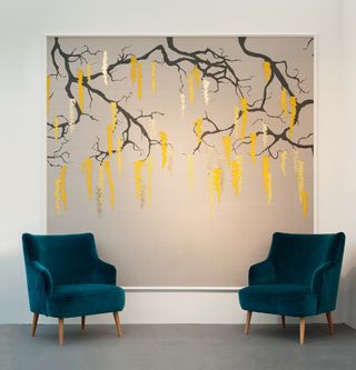 Blue arm chairs with wallpaper in between resembling a tree