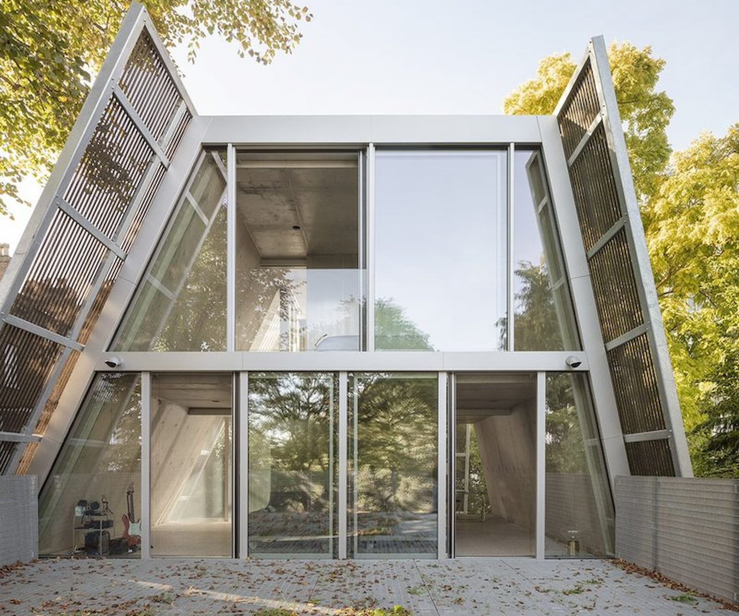 A rooftop of a house with tall window wall leading onto a balcony