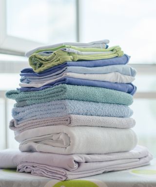 An image showing a stack of freshly washed and dried cleaning cloths of multiple colors