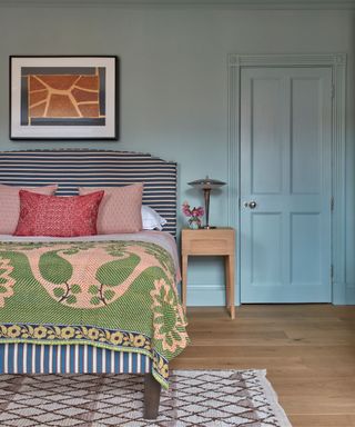 Blue bedroom with striped fabric headboard