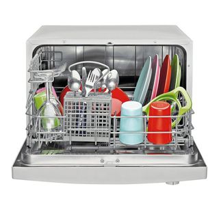 Open counter top dishwasher with clean dishes inside