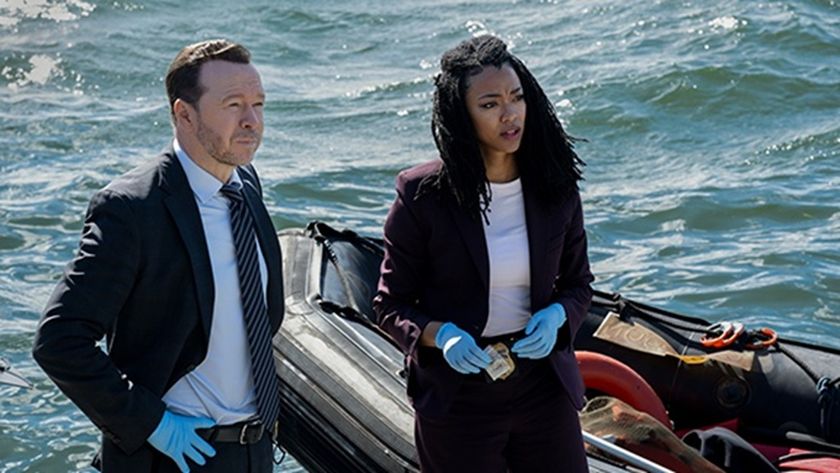 Detectives Danny Reagan (Donnie Wahlberg) and Lena Silver (Sonequa Martin-Green) look serious in smart suits while investigating a homicide by the sparking waters of Boston Harbor in spin-off series &quot;Boston Blue&quot;.