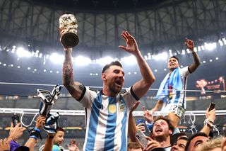 Lionel Messi celebrates with the World Cup trophy after Argentina's win at Qatar 2022.