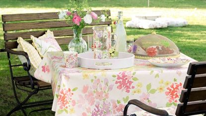 dinning table with floral cover wooden bench in garden