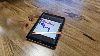 Logitech Crayon stylus and iPad on wooden desk