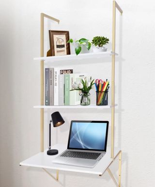 A wall desk with decor and a laptop on it