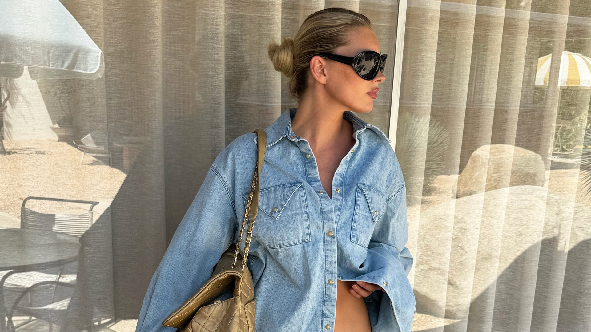 Elsa Hosk wearing a denim shirt, light-blue balloon track pants, a Chanel maxi flap bag, and Chanel aqua ballet flats