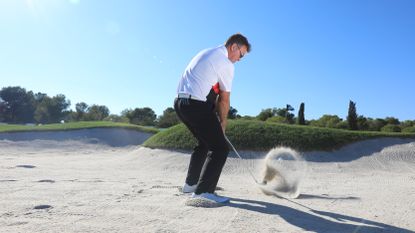 PGA pro John Jacobs demonstrating how much sand to take when hitting a bunker shot