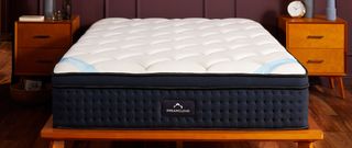 The DreamCloud Premier Hybrid Mattress on a wooden bedframe