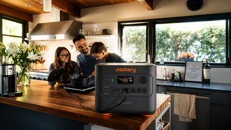 Family in kitchen cooking next to Jackery device
