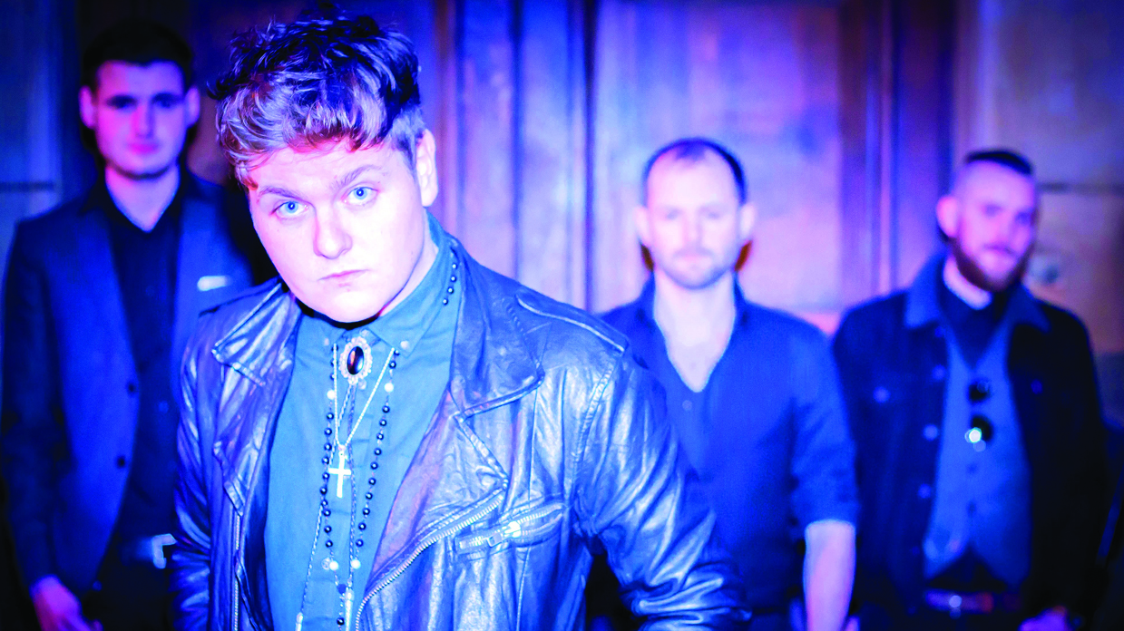 The four members of Broken Witt Rebels looking at the camera, bathed in blue light.