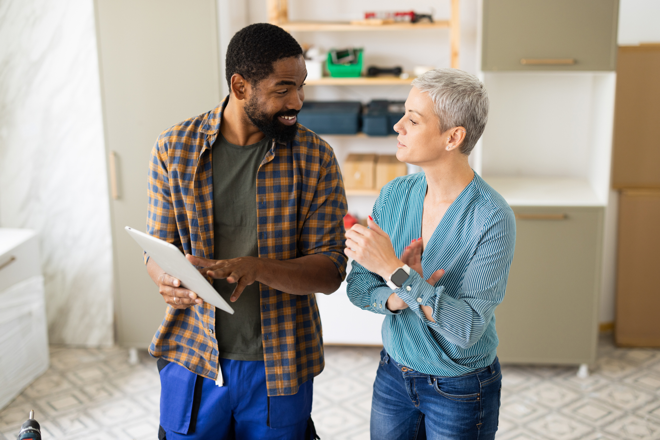 Contractor showing information on digital tablet to client during a home renovation