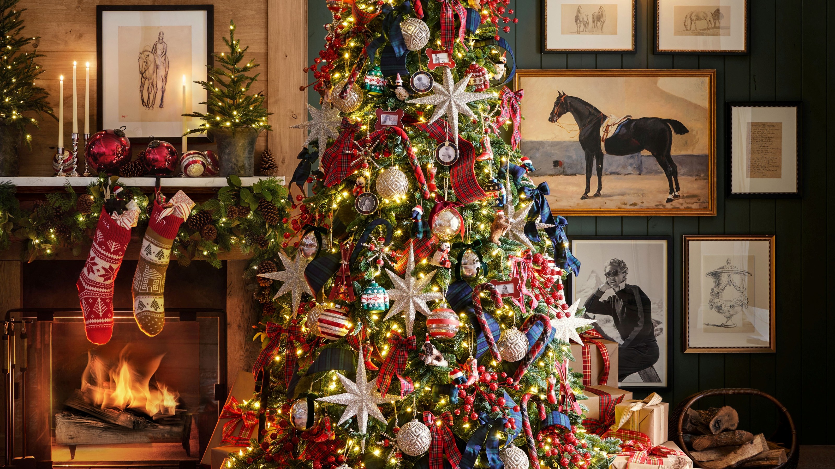 A Christmas tree next to a fireplace layered with Christmas decorations including photo frame ornaments from Pottery Barn