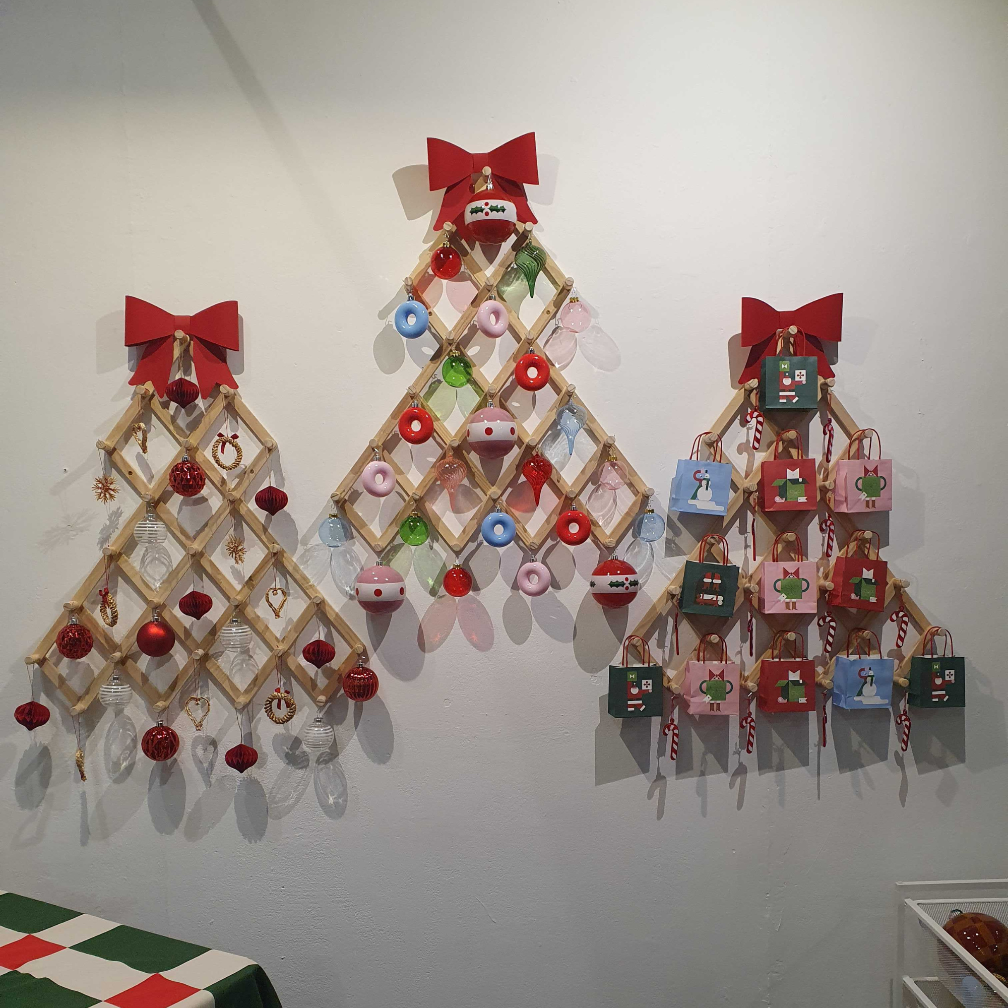 Three VINTERFINT trees on a wall holding a slection of differnt baubles