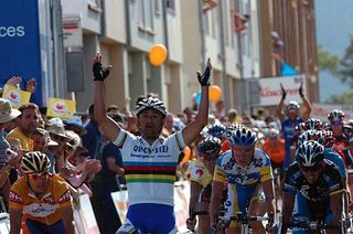 Paolo Bettini celebrates with his arms in the air.