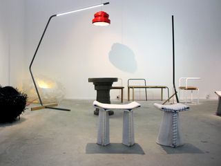 View of the Victor Hunt Designart Dealer exhibition space featuring the 'Stitching Concrete' series by Florian Schmid, a large black and red floor lamp and other pieces