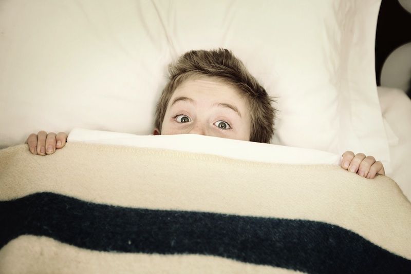 boy hiding in bed