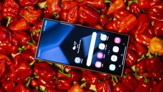 A Samsung Galaxy S24 Ultra sitting on top of a pile of red chillies