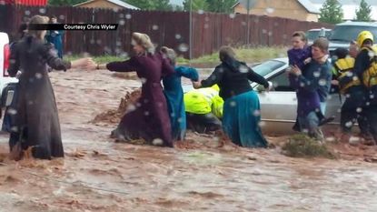 People in Hildale, Utah, try to escape from flood waters.