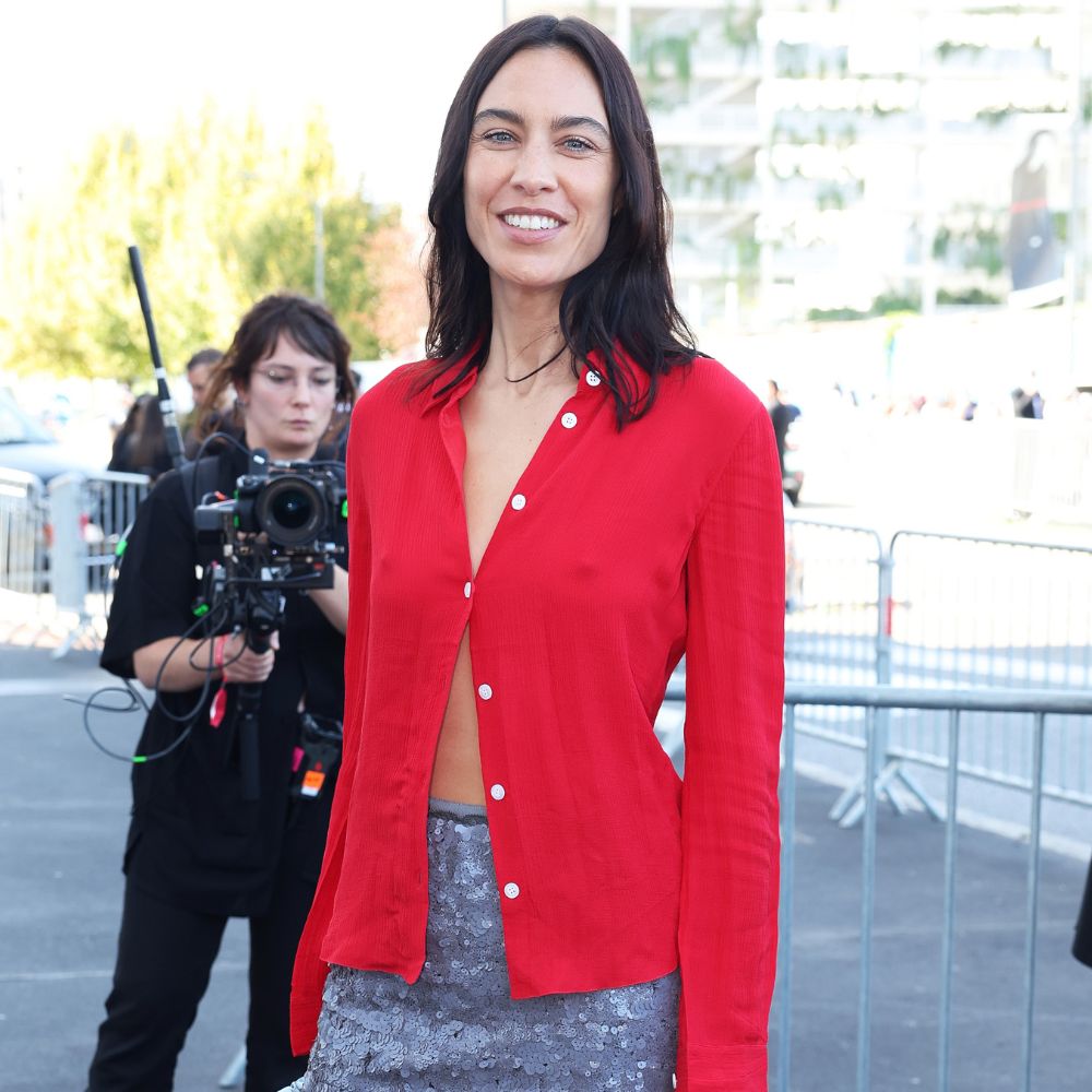 Alexa Chung arrives at the Prada runway show in Milan wearing a red button-down with a sparkly knee-length skirt and black slingback heels.