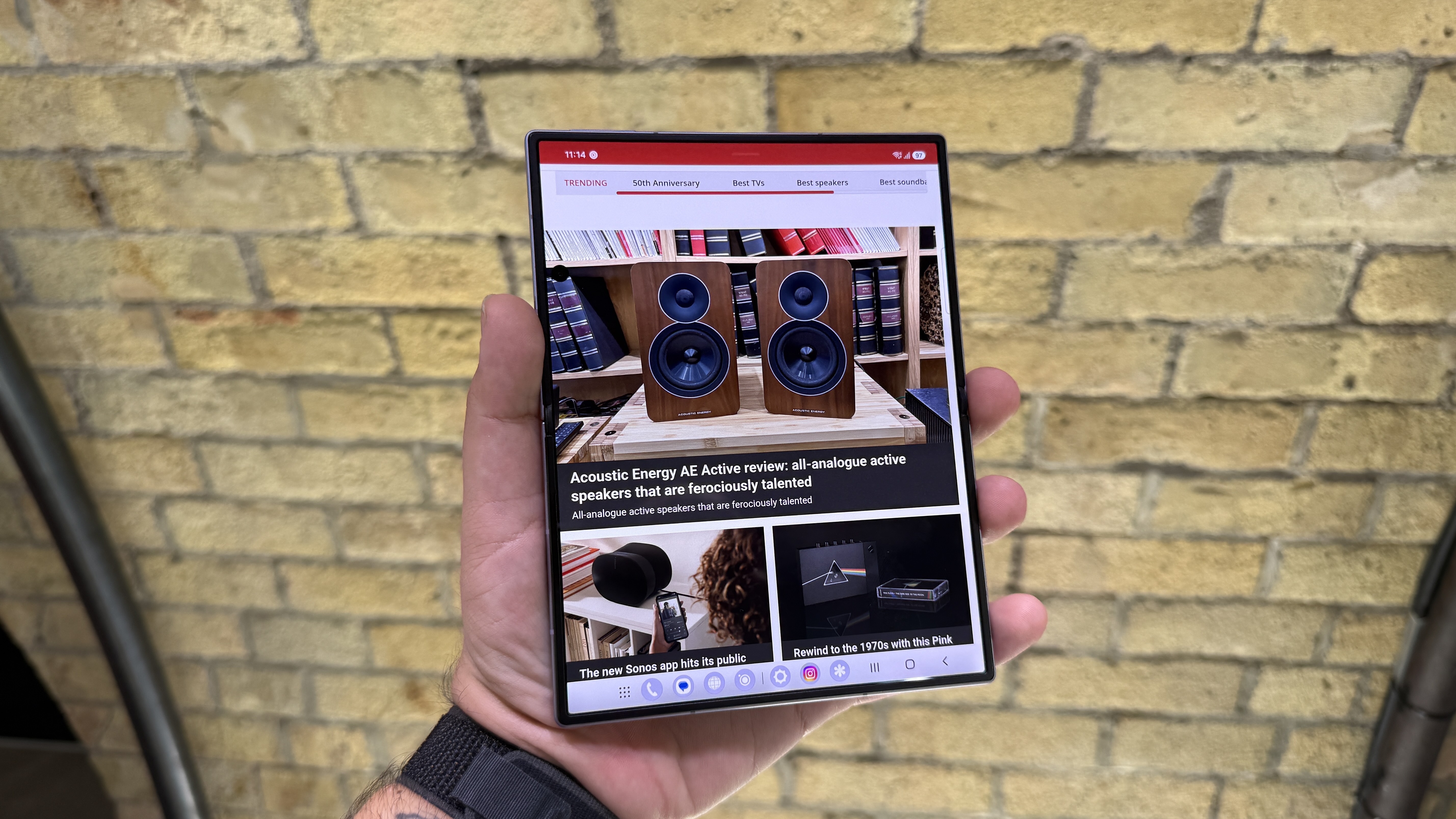 Samsung Galaxy Z Fold 8 and 8 Ultra in hand at a hands on event with a brick wall in the background