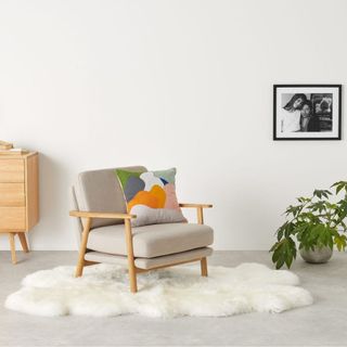 white room with armchair and plant pot