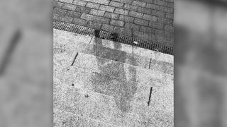 A sombra de uma pessoa nos degraus de um banco em Hiroshima, Japão.