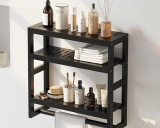 A black three-tier storage shelf in the bathroom filled with products