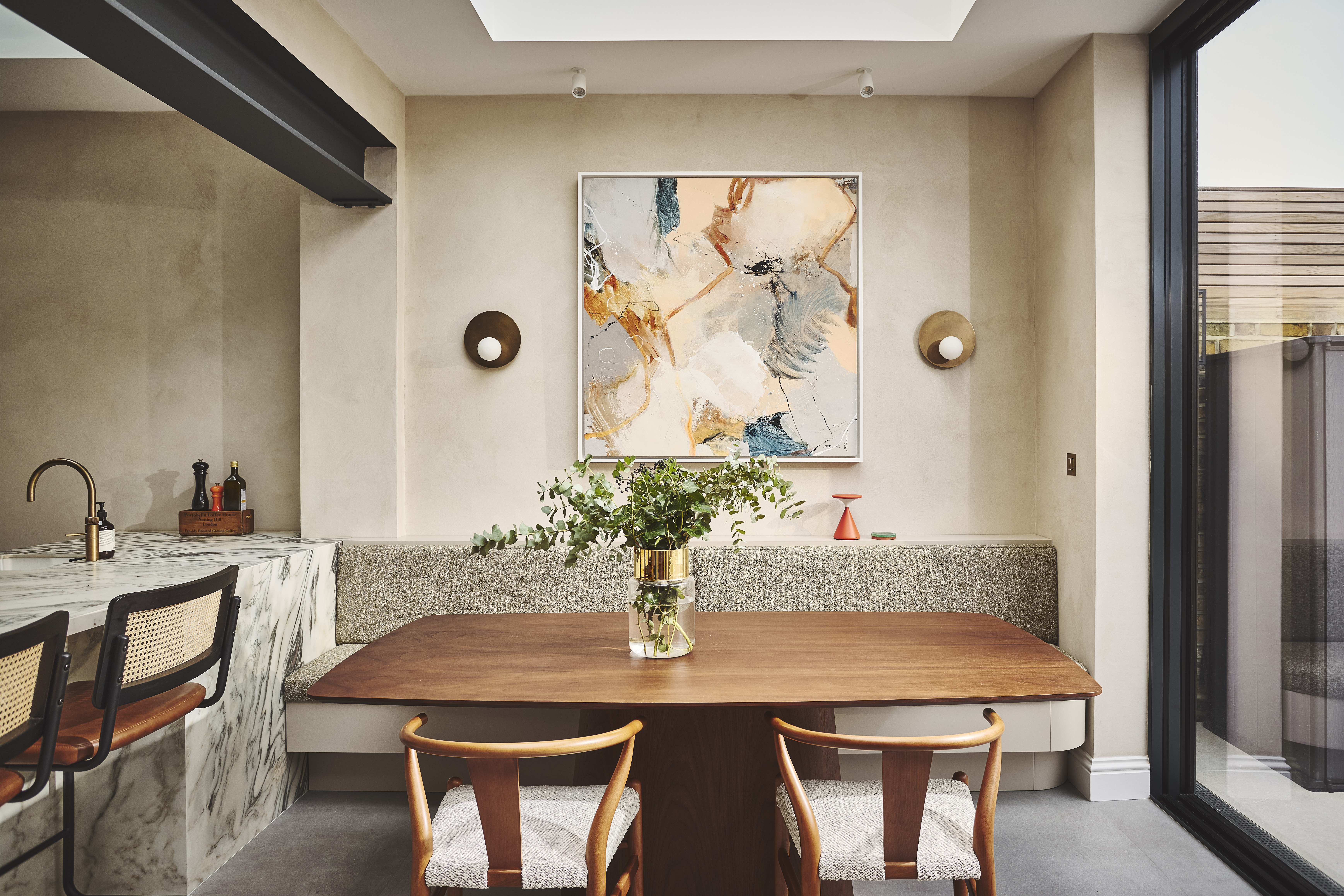 banquette seating area in a kitchen extension with mottled walls, wooden details and lots of natural light