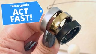 Close-up of three Samsung Galaxy Rings shown in a users hand in black, silver and gold next to a deals badge that says 'Act fast!'