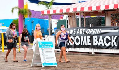 People walk along the Santa Monica Pier.