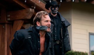 Josh Lucas bound and gagged by a sinister Purger in The Forever Purge.