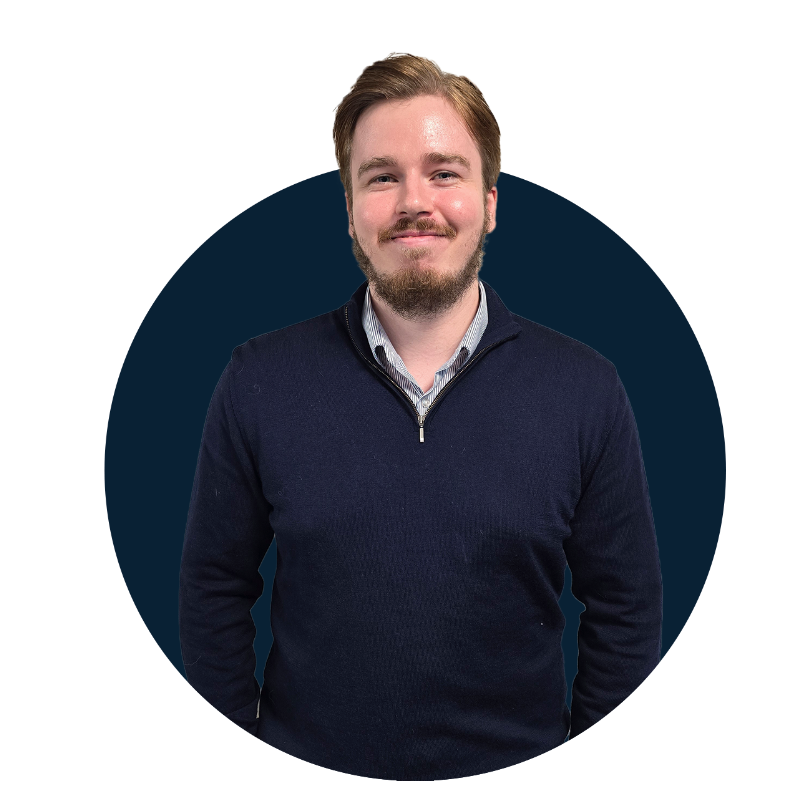 man with short hair and beard wearing blue jumper and shirt